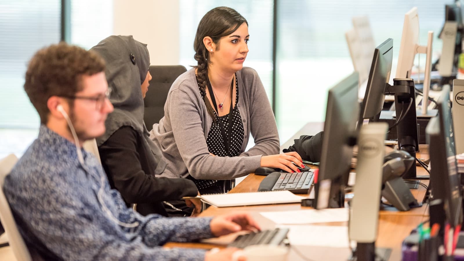 Organisers working replies at a bank of screens